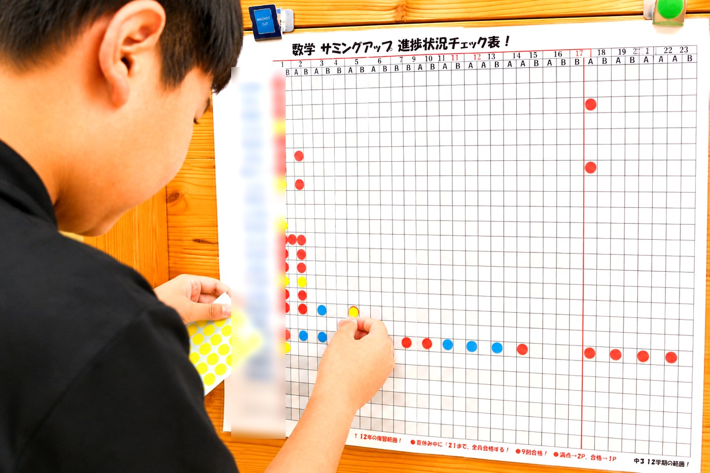 チェック表にシールを貼る中学3年生のTくん